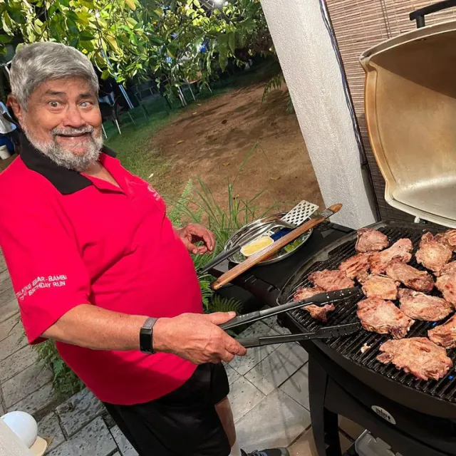 CH3 member cooking food on an outdoor barbecue after a run