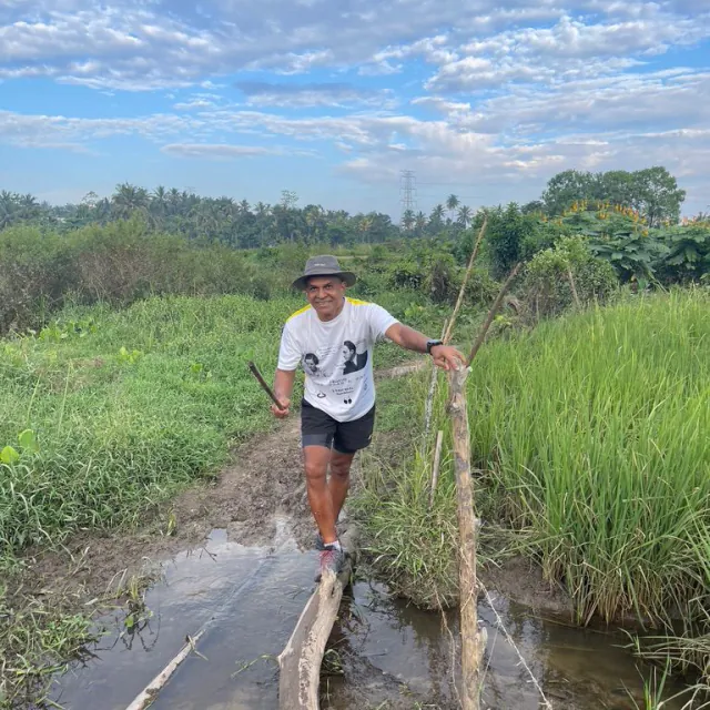 CH3 hasher balancing on a log above a muddy wetland trail
